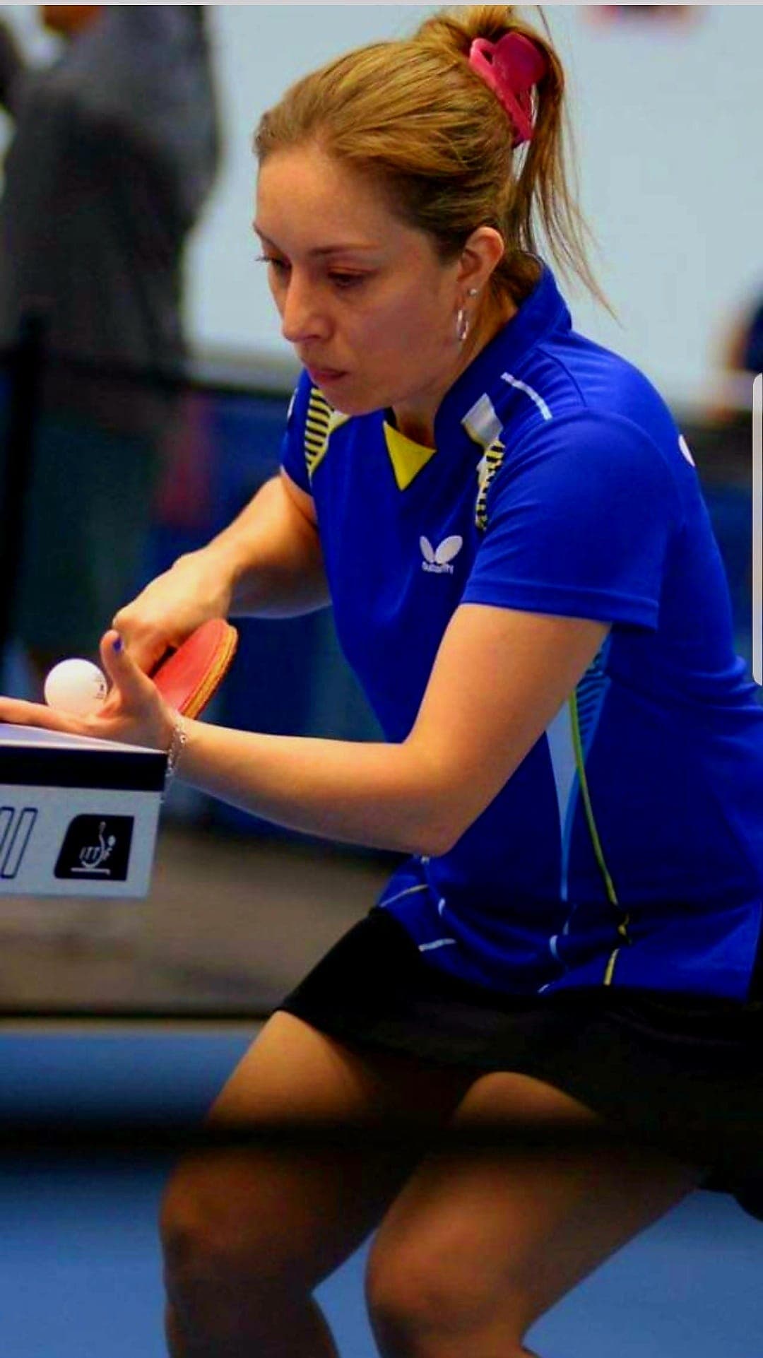Coach Lady Ruano serving, back view